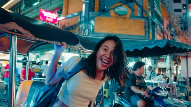 young-asian-woman-tourist-traveling-by-a-tuk-tuk-vehicle-on-the-street-at-bangkok-thailand