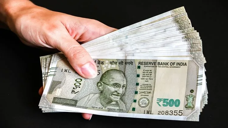 Woman's hands with new indian 500 rupees banknotes.